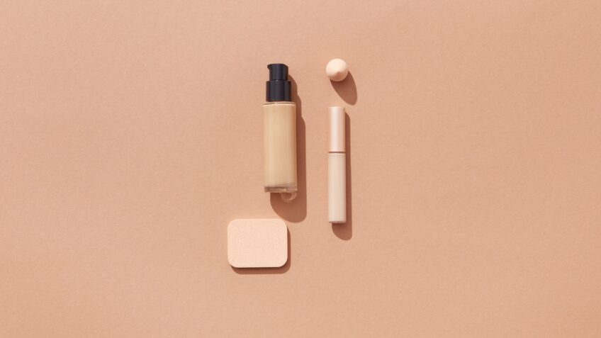 Flat lay of beauty products on a warm brown background