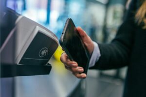 Woman checking a cashback rewards app on her smartphone while shopping