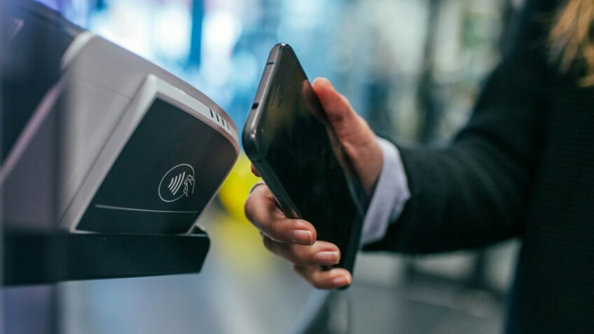 Woman checking a cashback rewards app on her smartphone while shopping