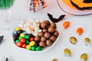Festive Halloween candy assortment with chocolate, marshmallows, and jack-o'-lantern decor