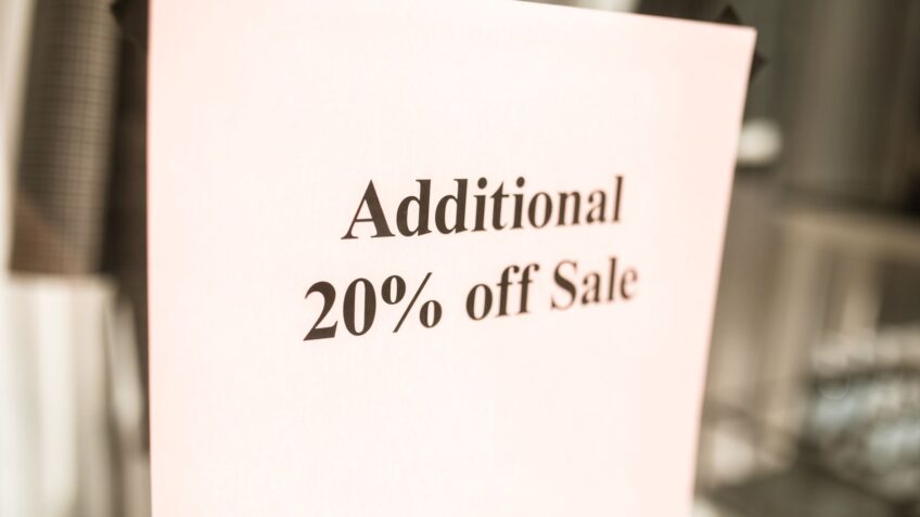 Close-up of a discount sign in a store window advertising a sale