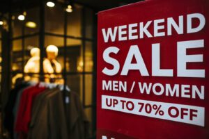 Weekend sale signage displayed in a store window for Labor Day