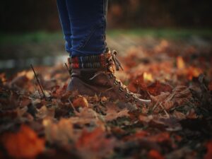 Close-up of leather boots on dry autumn leaves highlighting fall fashion