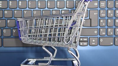 Miniature shopping cart on a laptop keyboard symbolizing online shopping and e-commerce
