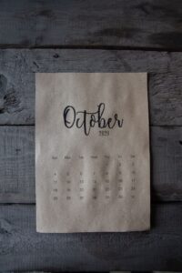 October calendar page on a wooden surface representing upcoming fall sales