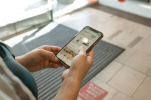 Hands holding a smartphone displaying a price tracking shopping app