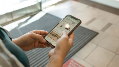 Hands holding a smartphone displaying a price tracking shopping app