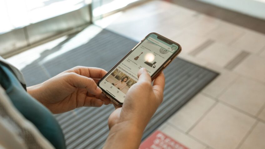 Hands holding a smartphone displaying a price tracking shopping app