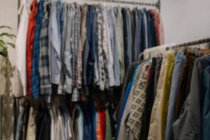 Assorted clothing hanging on racks in a thrift shop